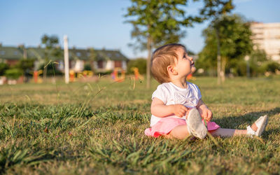 Cute girl sitting on field