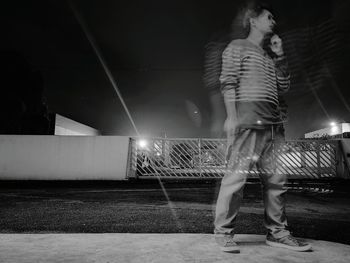 Woman standing on umbrella at night