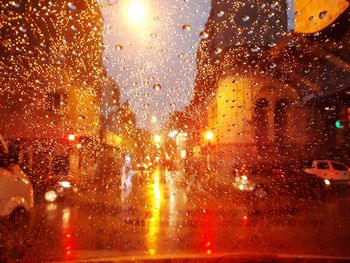 Illuminated street seen through wet glass