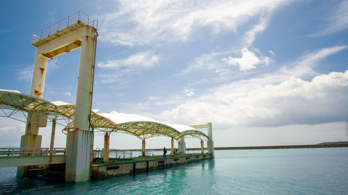 View of bridge over sea against cloudy sky