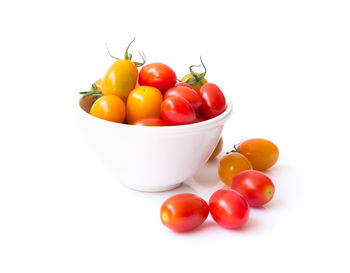 Close-up of tomatoes in bowl against white background