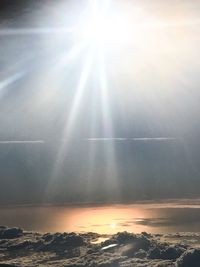 Sunlight streaming through clouds over sea