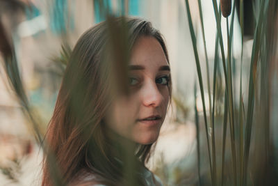 Portrait of woman standing by plants