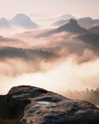 Fantastic dreamy daybreak above peaks of smoky mountain with the view into misty valley. 