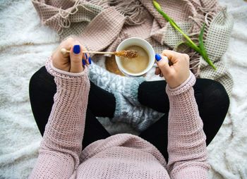 Low section of woman drinking coffee