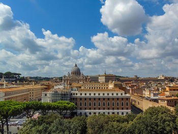 Buildings in city against cloudy sky