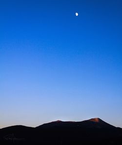 Scenic view of mountains against clear blue sky