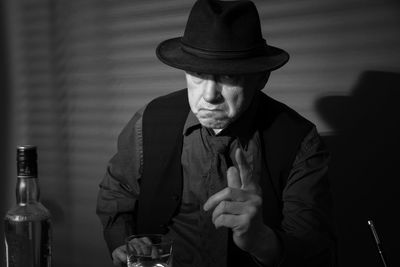 Portrait of man drinking alcohol while sitting at table