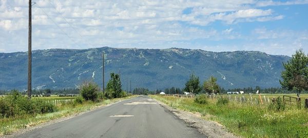 Road amidst trees against sky