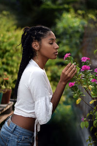 Young black woman smelling flowers