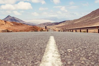 Surface level of empty road against mountain range