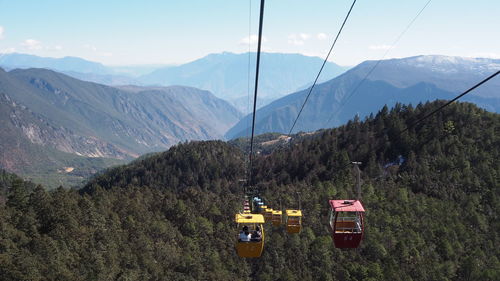 Overhead cable car on mountains against sky