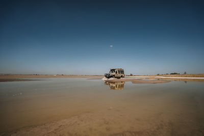 Toyota landcruiser driving through puddle in the desert with reflection