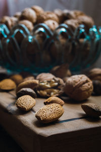 Walnuts and almonds in a blue glass bowl on a rustic wooden table