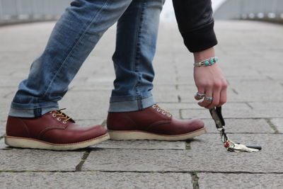 Low section of man with keys standing on street