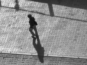 Shadow of man walking on footpath