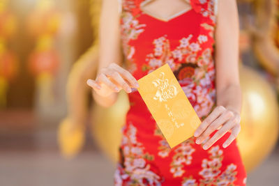 Close-up of woman holding red flower