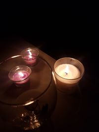 High angle view of illuminated tea light candles in darkroom