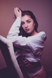 Portrait of young woman against gray background