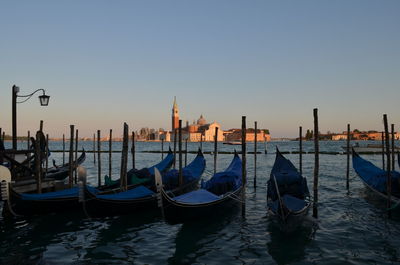 Gondolas at port against church of san giorgio maggiore