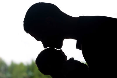 Close-up portrait of silhouette man statue against sky