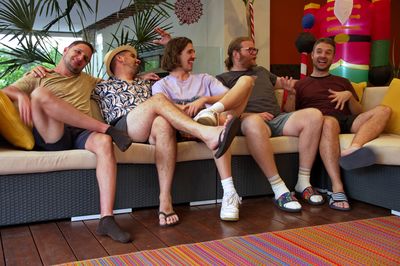 Group of handsome young men sitting on a porch