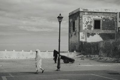 Rear view of people on street against building