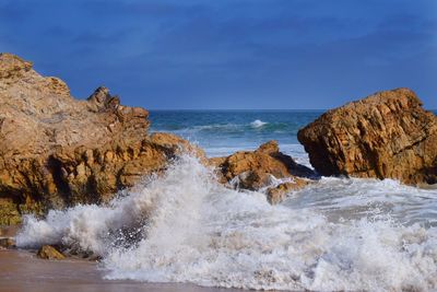 Waves splashing rocks in sea