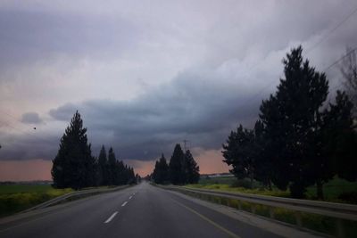 Road amidst trees against sky