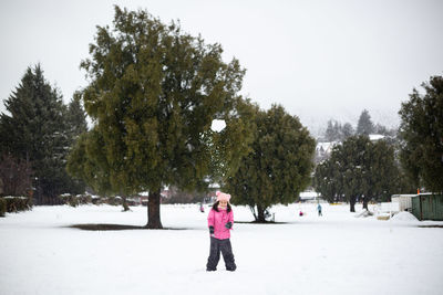 Rear view of woman walking on snow covered landscape