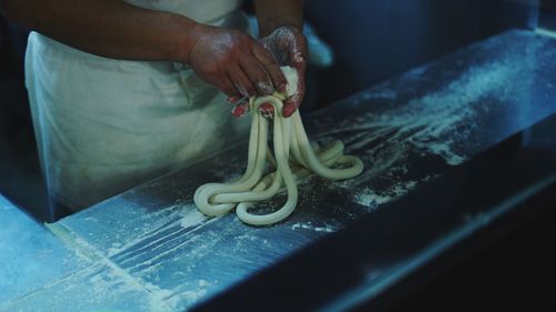 Midsection of person preparing food on cutting board