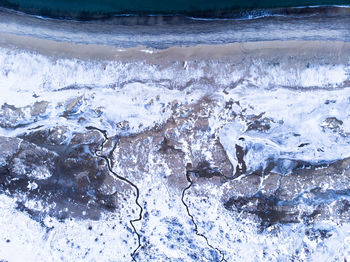 Wide view of sand beach covered partially with snow during winter in the arctic