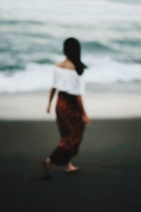 Rear view of woman standing on beach