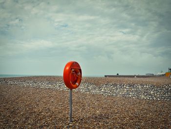 Red umbrella on beach against sky