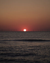 Scenic view of sea against orange sky