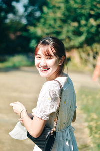 Portrait of young woman standing on field