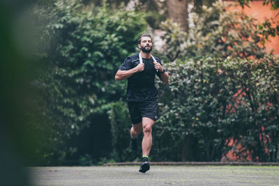 Man running outside in the park. fit boy doing exercise outdoor. beautiful sporty male run alone. 