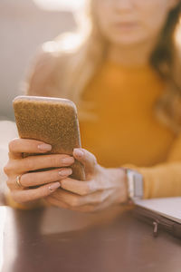 Midsection of woman using mobile phone