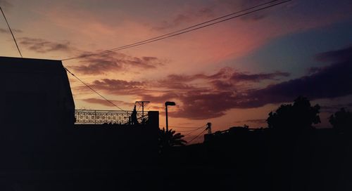 Low angle view of silhouette building against sky at sunset