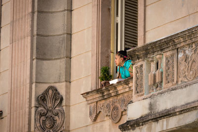 Side view of man standing against building