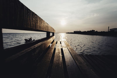 Pier over sea against sky during sunset