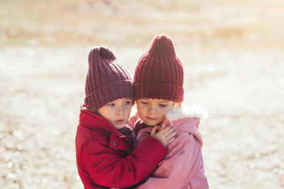 Portrait of young woman standing on sand at beach