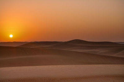 Scenic view of desert against sky during sunset