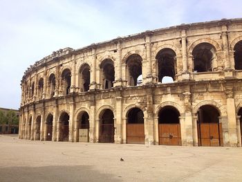 Arcade of coliseum against sky