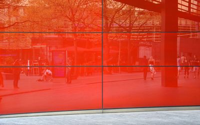 Reflection in modern red glass facade in city