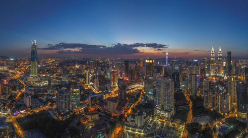 Aerial view of illuminated city against sky