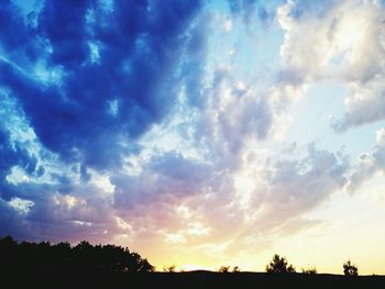 Silhouette of landscape against cloudy sky