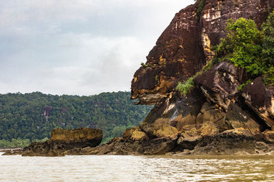 Rock formations by sea against sky