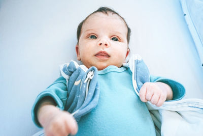 High angle view of baby lying on crib