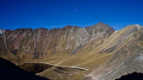 Low angle view of mountains against blue sky